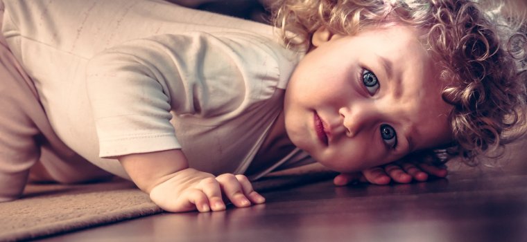Worried child looking for monsters under her bed